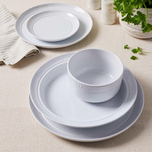 Staub white dinnerware set with bowl and plate stacks, round logo