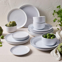Staub white dinnerware set with stacked plates and bowls, round logo