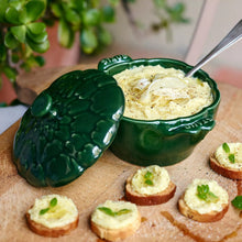 Staub artichoke cocotte with lid open, green glaze, holding prepared dish