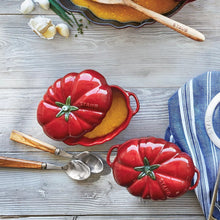 Pair of red tomato cocottes with lids and green stems, side handles