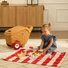 Child’s toy picnic basket with red wheels and handle, beige brick-style body