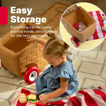 Open toy picnic basket with accessories inside while child plays on red-and-white mat