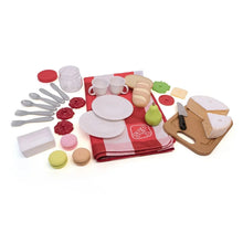 Toy picnic accessories set with plates, cups, utensils, and pretend food pieces on mat
