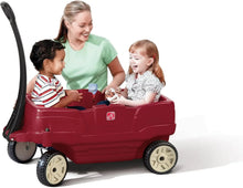 Red plastic ride-on wagon with open seat, steering handle, and two kids riding