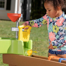 Kids playing at green water activity pump with yellow and red water parts