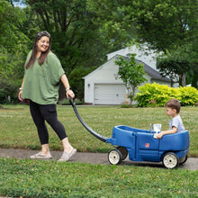 Blue kids ride-on wagon with front handle and cup tray, child seated outdoors