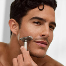Man shaving with a razor near his cheek during grooming