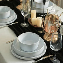 Celina dinnerware set on table with light gray bowls, plates, and serving items
