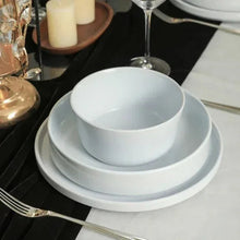 Celina dinnerware set: stacked light gray bowls and plates on table
