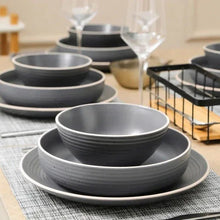 Gray speckled stoneware dinnerware set with layered bowls and plates on table