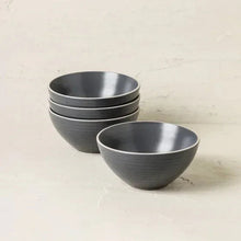 Gray stoneware dinnerware set showing bowls in front with stacked plates behind