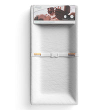 Packaged white contoured changing pad with raised sides and strap fastener