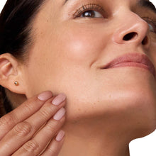 Face cream being applied to cheek area with fingers, smoothing