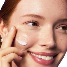 Hyaluronic acid serum application, white cream on cheek with fingertip