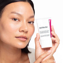 StriVectin SD Advanced Plus intensive moisturizer tube held by hand, white with pink band
