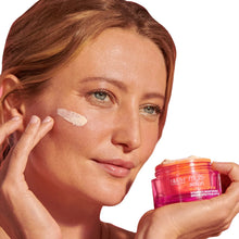 Vitamin C SPF moisturizer jar held near face with cream applied