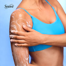 Exfoliating body wash applied to skin on leg, with suds and blue bikini top