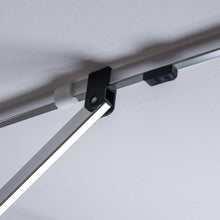 Patio umbrella support bar with black clamp under white canopy