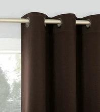 Blackout curtain header with metal grommets on rod, dark brown fabric
