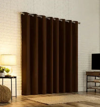 Blackout curtain panels with metal grommets, dark brown/black, hung in window space