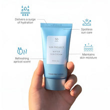 Hand holding a light blue sunscreen tube with white label and blue cap