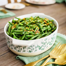 Oval ceramic baker dish with green herb-pattern sides, filled with green beans