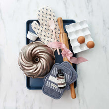 Blue nonstick half sheet pan with bake-ready ingredients arranged on it