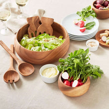 Curved acacia wood salad bowl filled with leafy greens and vegetables