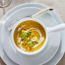 Light blue round salad plate with shallow rim, holding a bowl of soup.