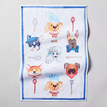 Dog kitchen towel with playful dog faces, utensils, and blue border on white fabric