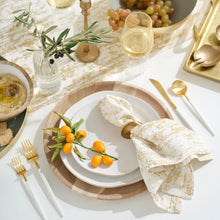 Round dinner plate with gold rim and white surface, on a wooden tray
