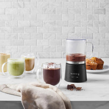 Milk frother base with clear pitcher, with frothy drinks in cups