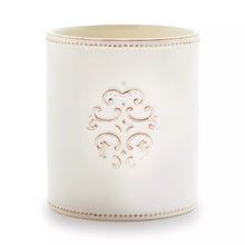 White stoneware utensil crock with ornate embossed medallion on side