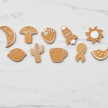 Assorted baked cookie cutouts in sun, mushroom, cactus, fish, and other shapes