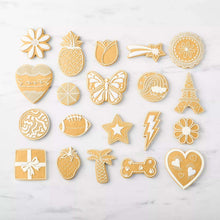 Assorted gold cookie cutters in floral and holiday shapes, including a tulip