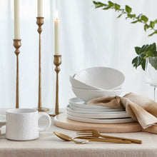Stacked white coupe cereal bowls on a wooden serving board
