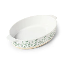 Oval ceramic baker dish with white interior and green herb-pattern sides