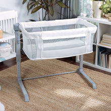 Cream co-sleeping bassinet with airy mesh sides and padded base, upright view
