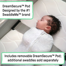 Baby lying in cream co-sleeping bassinet with cushioned insert