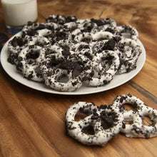 Pretzel cookies on white plate, dark chocolate with white icing and cookie crumbs