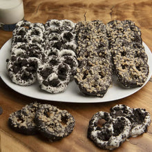 Pretzel cookies assortment on plate, dark chocolate with white icing and sprinkles
