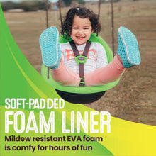 Green baby swing with smiling toddler seated, harness straps and blue shoes