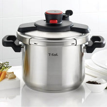 Stainless steel stovetop pressure cooker with black handles and red control on lid