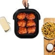 T-fal air fryer basket with cooked fries and chicken inside open unit