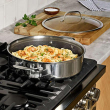 Stainless steel universal pan with glass lid, side handles, and perforated mesh interior