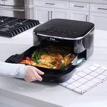 Black infrared air fryer with open basket holding roasted vegetables and chicken