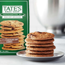 Stack of chocolate chip cookies on a white plate beside the cookie bag