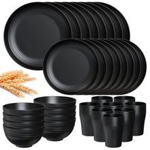 Black wheat-straw dinnerware set with stacked dinner plates, bowls, and cups