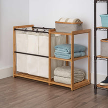 Bamboo laundry station with 3 hanging white bag compartments and towel shelves
