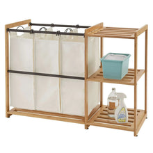 Bamboo laundry station with hanging white bags and two-tier wooden shelf
